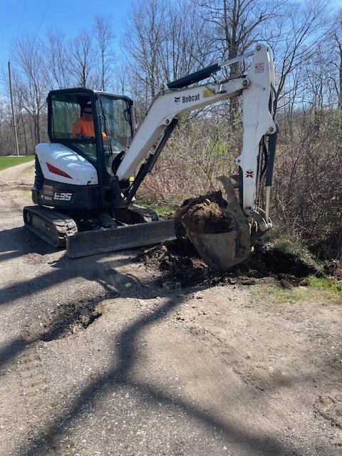 Excavator pulling out tree stump during land prep