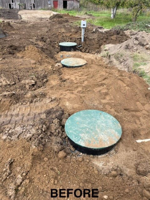 Three septic tank lids exposed before final grading and seeding